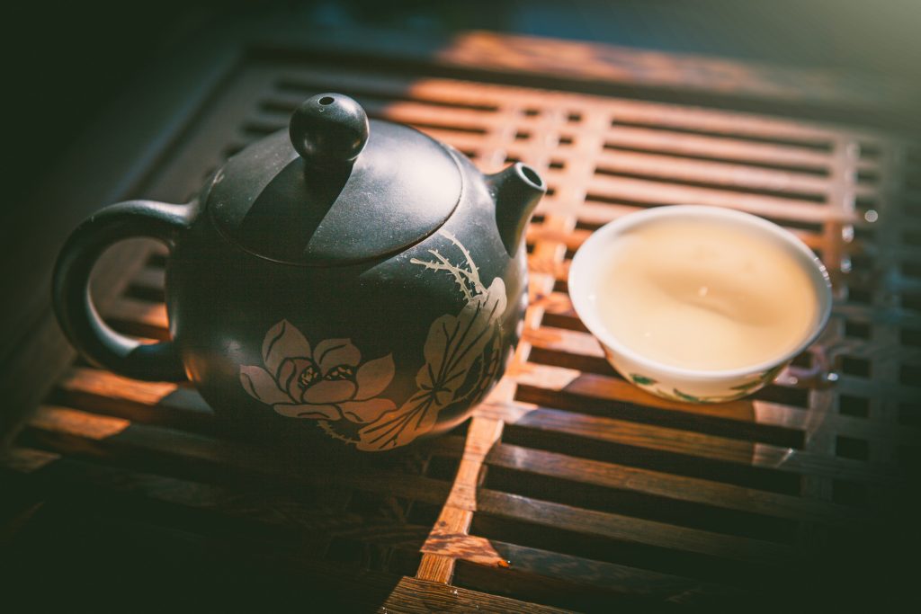 Chinese tea ceremony. Teapot and a cup of tie guan yin on wooden table.
