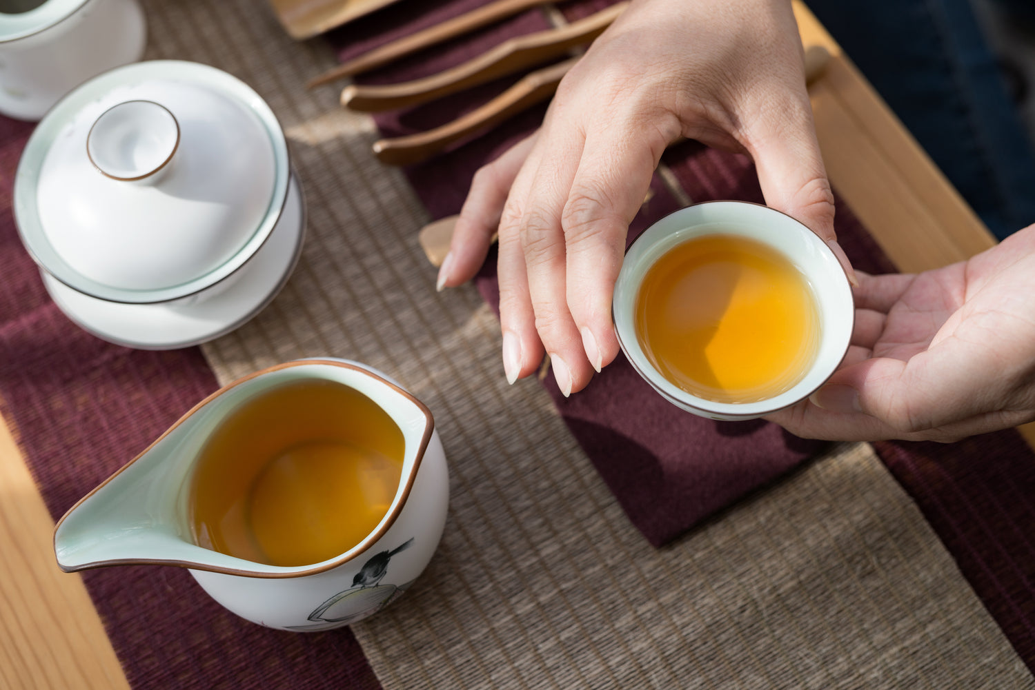 woman offering a cup of oolong tea