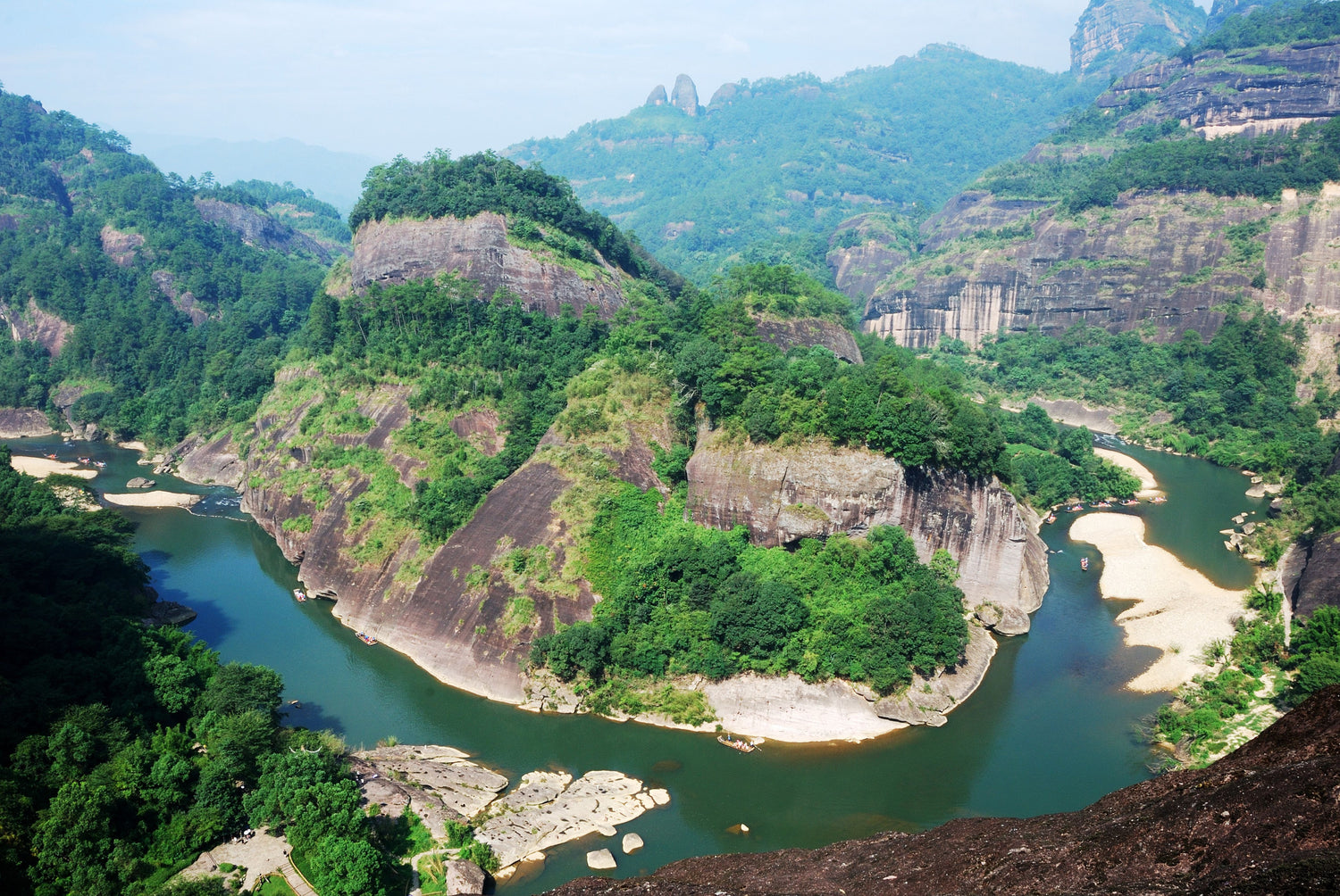 view of a distinct rock formation in the middle of a winding river in the wuyi mountains, home of imperial red robe (da hong pao) tea